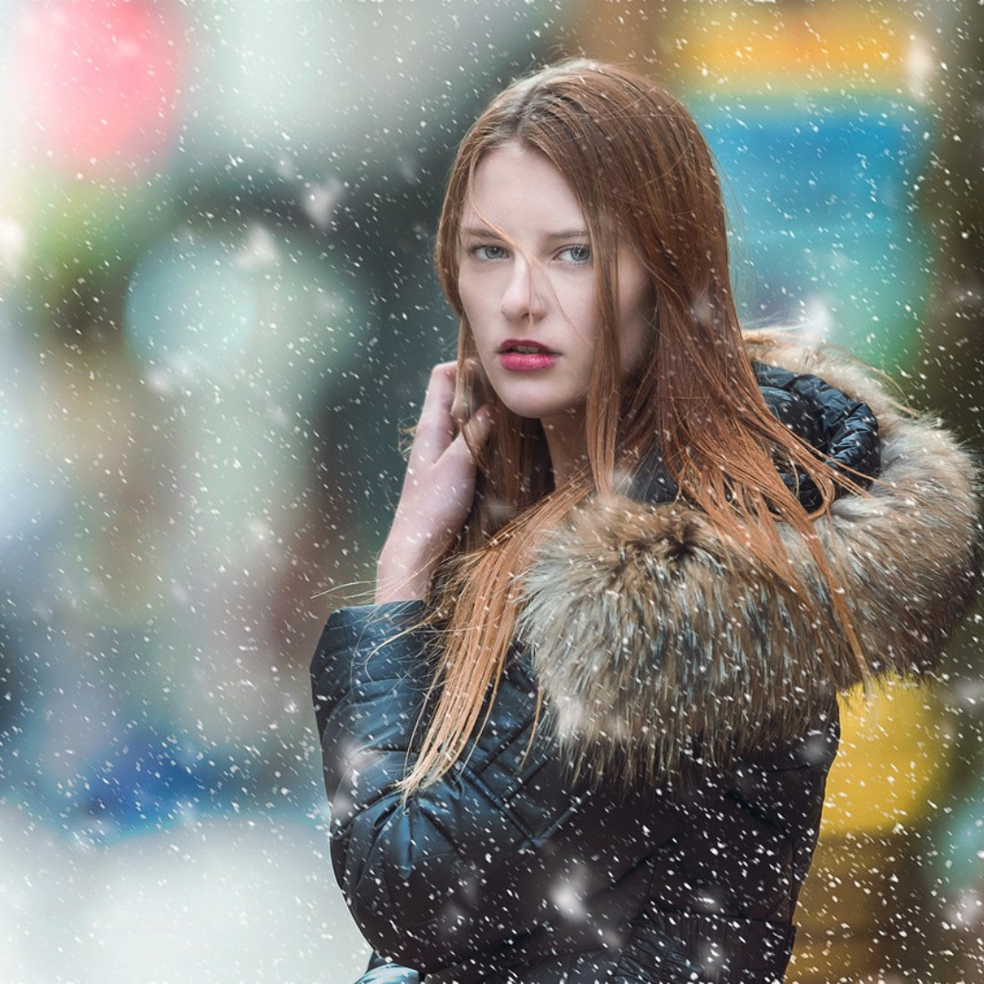 Frau im Schnee mit Winterjacke