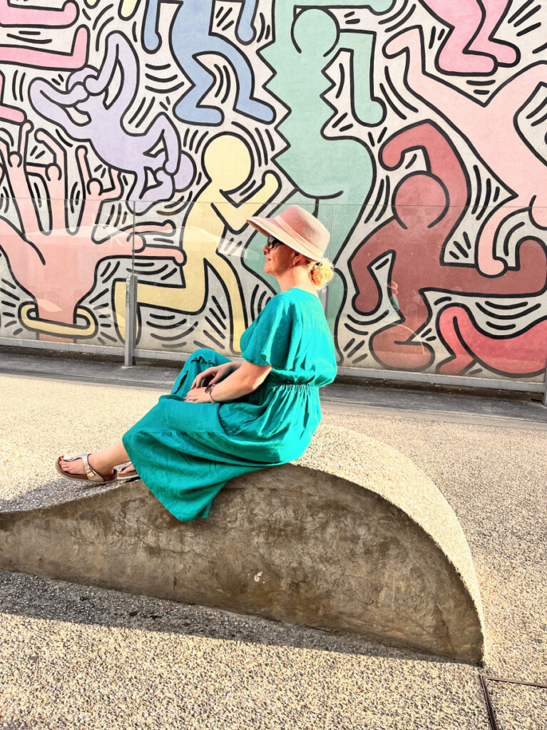 Frau mit Hut vor Gemälde Keith Haring in Pisa